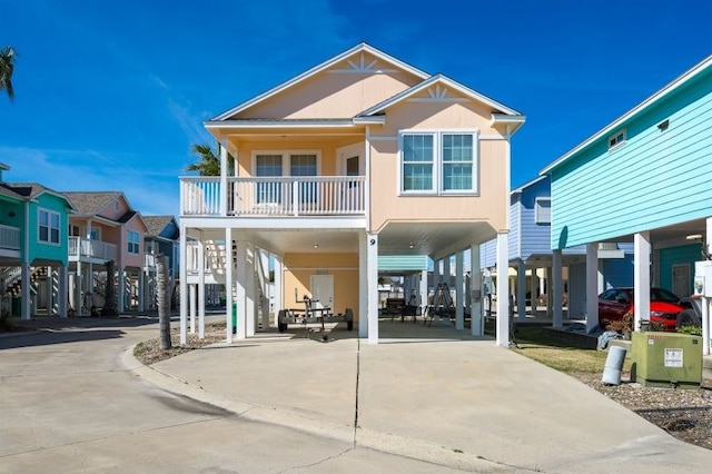 view of front of property featuring a carport, concrete driveway, and a balcony