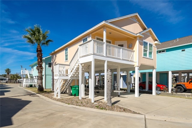 view of building exterior with a carport, driveway, and stairway