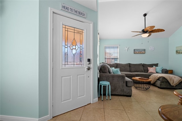 foyer with light tile patterned floors, lofted ceiling, a ceiling fan, and baseboards