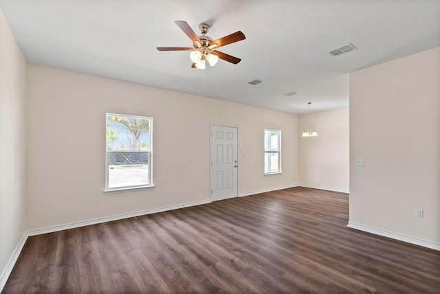 2201 Morris St, Corpus Christi, TX 78405 - empty room with dark wood-style flooring, ceiling fan, and a chandelier