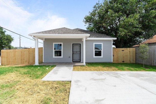 2201 Morris St, Corpus Christi, TX 78405 - view of front of home with a patio area, a fenced backyard, and a shingled roof