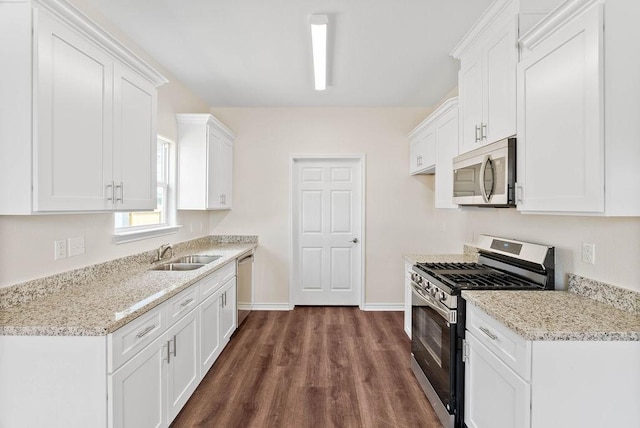 2201 Morris St, Corpus Christi, TX 78405 - kitchen with appliances with stainless steel finishes, dark wood-style flooring, white cabinets, and light stone countertops