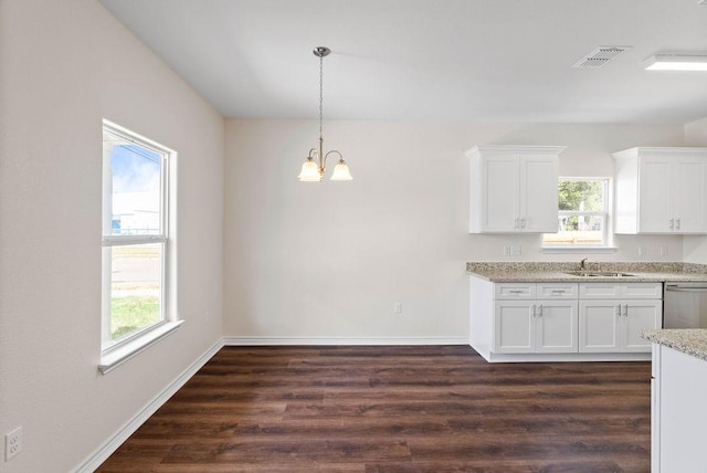 2201 Morris St, Corpus Christi, TX 78405 - kitchen with dishwasher, dark wood finished floors, white cabinets, and hanging light fixtures