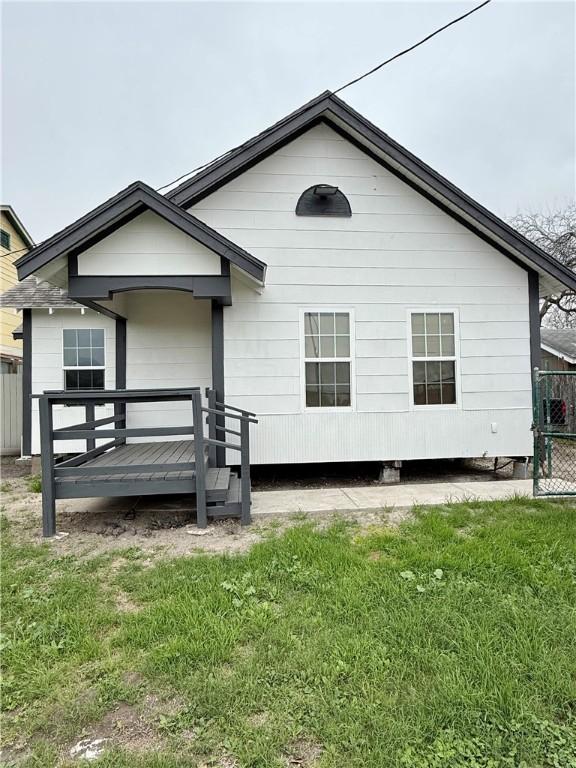 rear view of property featuring a wooden deck and a yard