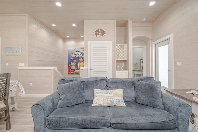 living room featuring light hardwood / wood-style floors and wooden walls