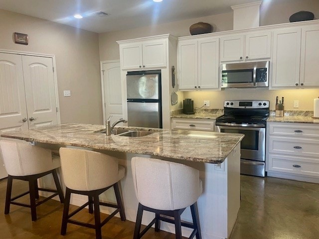 705 Monkey Rd, Rockport, TX 78382 - kitchen with appliances with stainless steel finishes, white cabinets, a breakfast bar, and recessed lighting