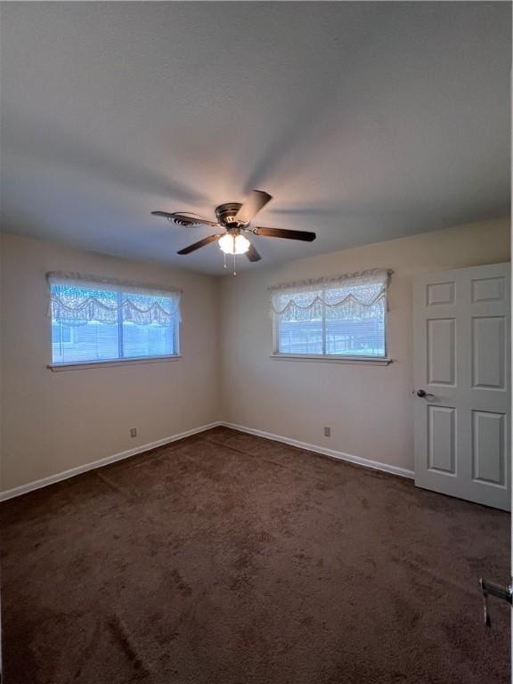 5825 San Saba Dr, Corpus Christi, TX 78407 - empty room with plenty of natural light, dark carpet, and a ceiling fan