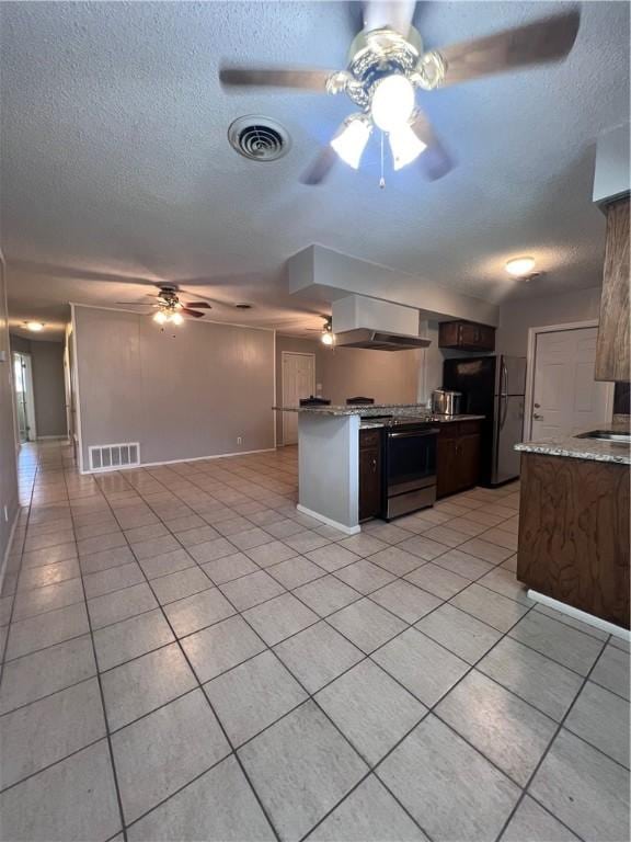 5825 San Saba Dr, Corpus Christi, TX 78407 - kitchen featuring electric stove, a ceiling fan, wall chimney exhaust hood, freestanding refrigerator, and light tile patterned flooring