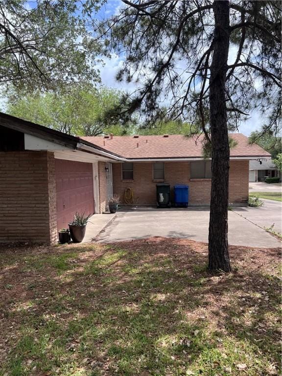 5825 San Saba Dr, Corpus Christi, TX 78407 - back of property featuring brick siding, an attached garage, and driveway