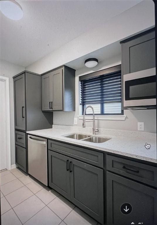 5825 San Saba Dr, Corpus Christi, TX 78407 - kitchen with appliances with stainless steel finishes, light tile patterned floors, and gray cabinets