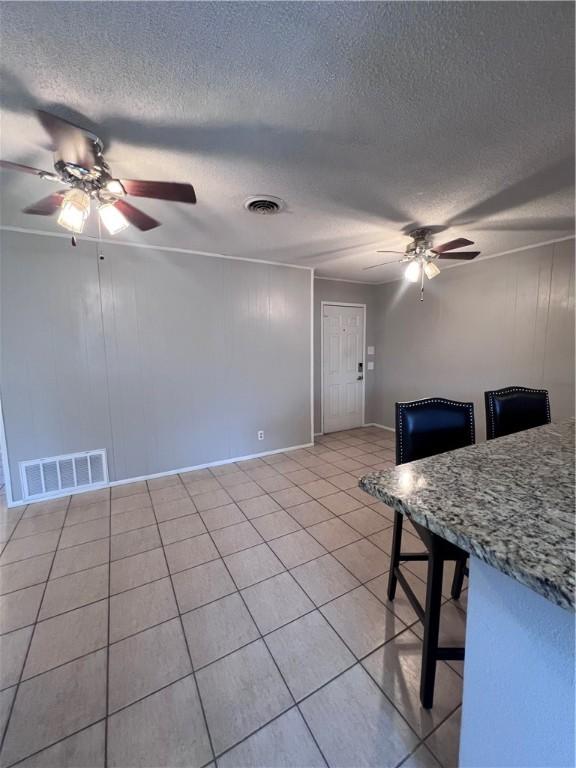 5825 San Saba Dr, Corpus Christi, TX 78407 - dining room with ceiling fan, light tile patterned floors, and a textured ceiling