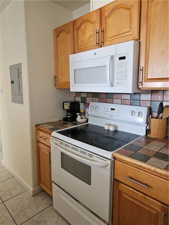 kitchen featuring backsplash, white appliances, tile counters, and electric panel