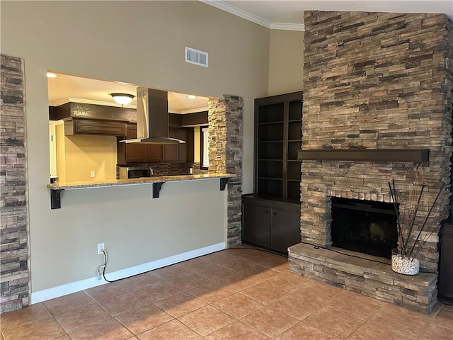 unfurnished living room featuring light tile patterned floors, ornamental molding, and a fireplace