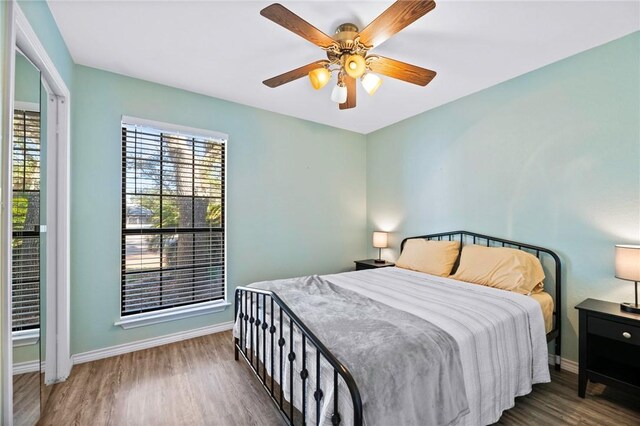 bedroom featuring ceiling fan, baseboards, and wood finished floors