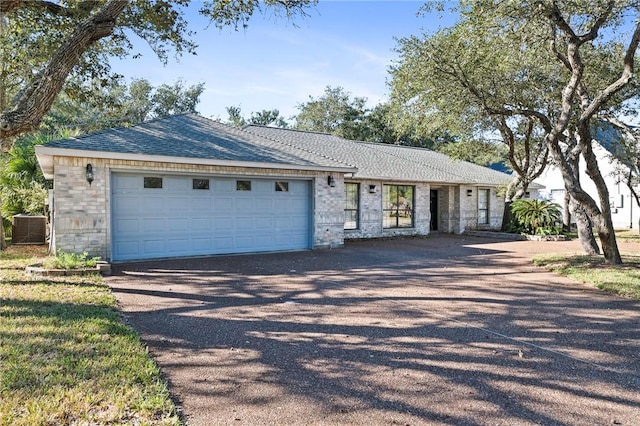 ranch-style house with cooling unit, a garage, and driveway