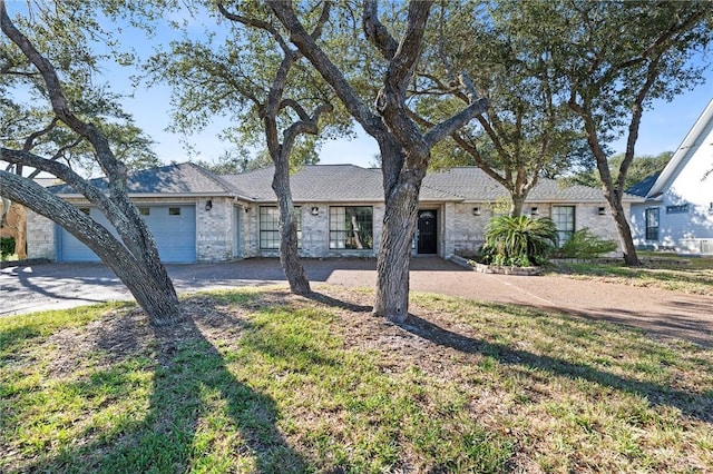 ranch-style home featuring an attached garage, brick siding, and driveway