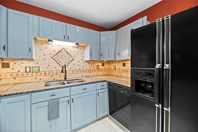 kitchen featuring light tile patterned floors, black appliances, tasteful backsplash, and a sink