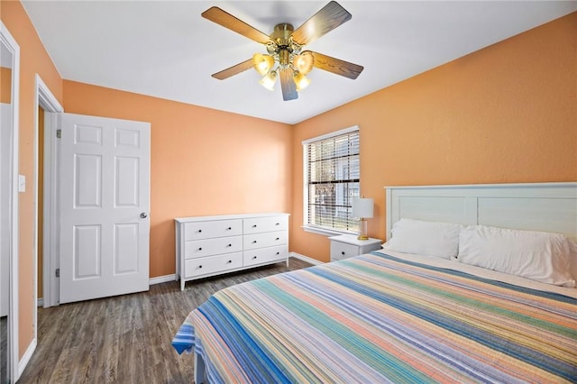 bedroom with a ceiling fan, wood finished floors, and baseboards