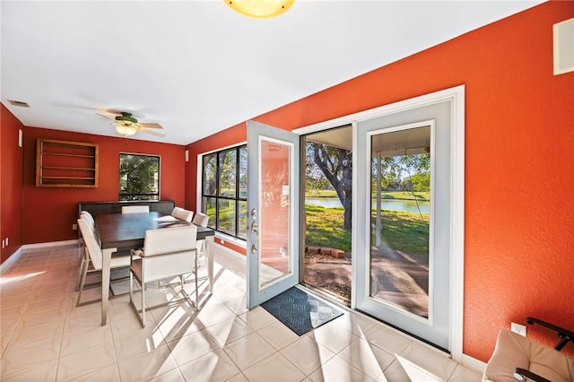 sunroom / solarium featuring visible vents, a water view, and ceiling fan