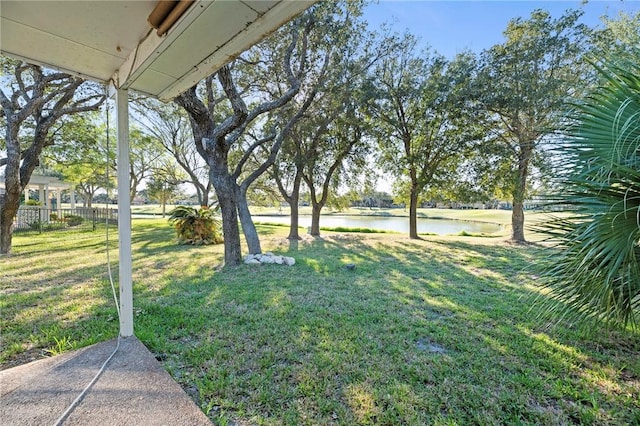 view of yard with a water view and fence