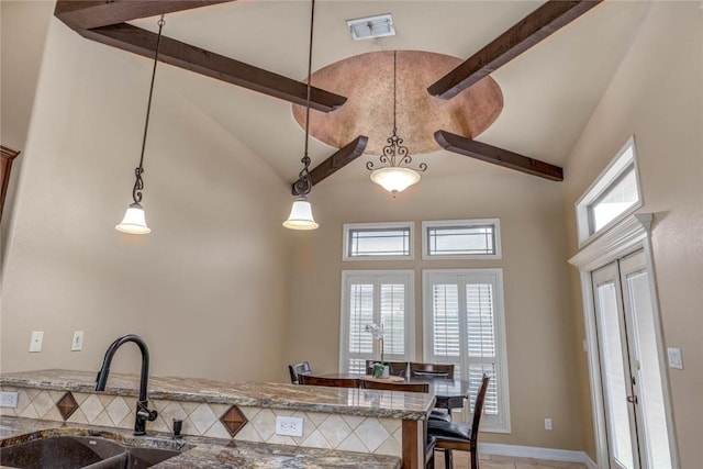 3722 Lake Hawkins Ct, Robstown, TX 78380 - kitchen featuring high vaulted ceiling, a sink, beamed ceiling, stone counters, and decorative light fixtures