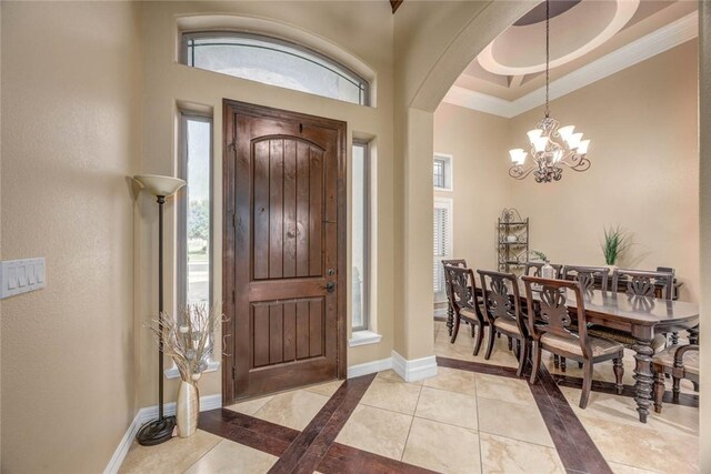 3722 Lake Hawkins Ct, Robstown, TX 78380 - foyer featuring arched walkways, plenty of natural light, a chandelier, light tile patterned floors, and crown molding