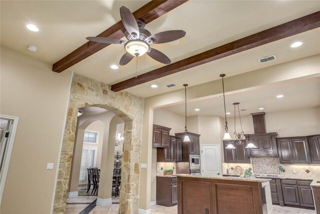 3722 Lake Hawkins Ct, Robstown, TX 78380 - kitchen with arched walkways, decorative backsplash, ceiling fan, dark brown cabinetry, and beamed ceiling