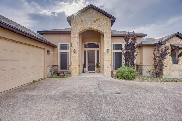 3722 Lake Hawkins Ct, Robstown, TX 78380 - property entrance featuring stone siding, stucco siding, driveway, and an attached garage