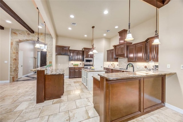 3722 Lake Hawkins Ct, Robstown, TX 78380 - kitchen featuring stainless steel appliances, a center island, backsplash, light stone counters, and a peninsula