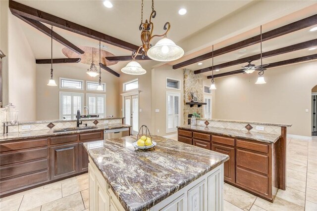 3722 Lake Hawkins Ct, Robstown, TX 78380 - kitchen featuring a ceiling fan, a center island, a sink, decorative backsplash, and beam ceiling