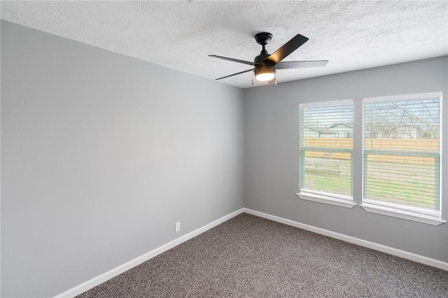 unfurnished room with carpet floors, ceiling fan, baseboards, and a textured ceiling