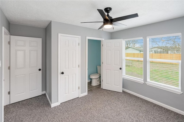 unfurnished bedroom with baseboards, a ceiling fan, a textured ceiling, carpet floors, and a closet