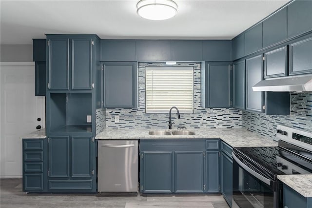 kitchen featuring decorative backsplash, appliances with stainless steel finishes, light wood-style floors, a sink, and under cabinet range hood