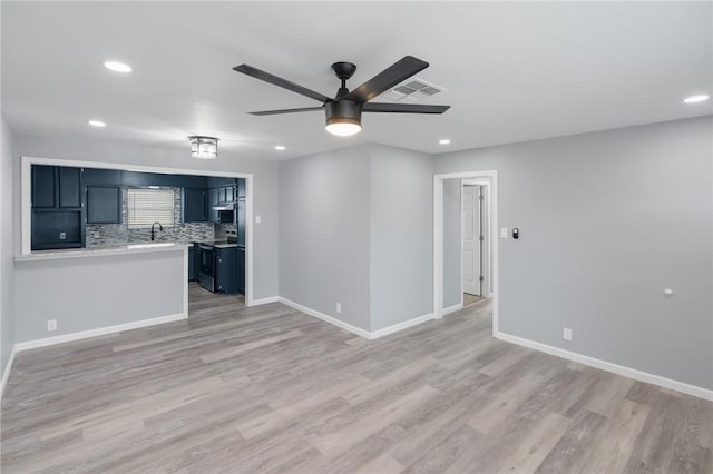 unfurnished living room with baseboards, visible vents, ceiling fan, and wood finished floors