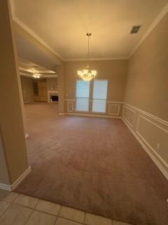 7502 Lourdes St, Corpus Christi, TX 78414 - unfurnished dining area featuring crown molding, a chandelier, carpet flooring, wainscoting, and a decorative wall