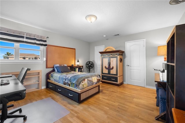 bedroom with light wood-style flooring, baseboards, and visible vents