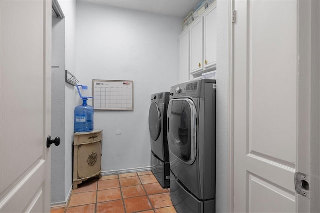 laundry area featuring cabinet space, light tile patterned floors, and washing machine and dryer