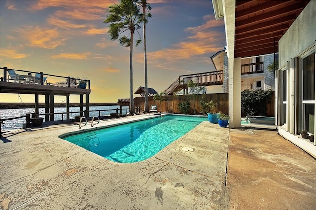 pool at dusk featuring a fenced in pool, a patio, and fence