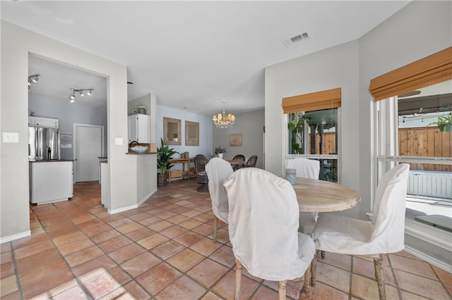 dining room featuring a notable chandelier, baseboards, visible vents, and light tile patterned floors