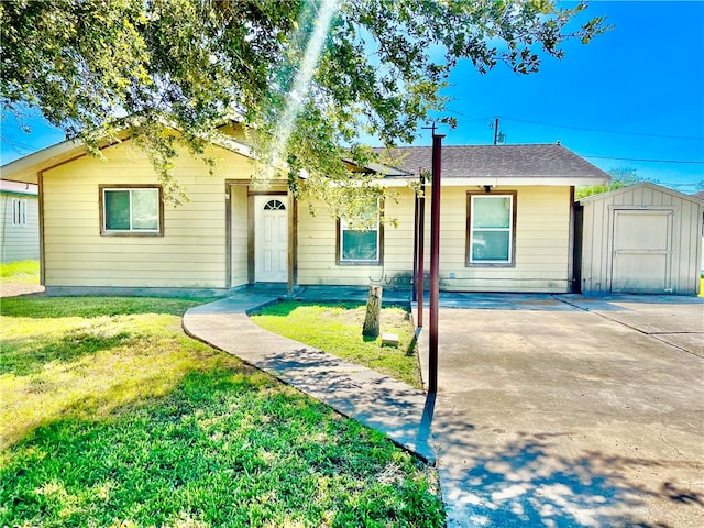 ranch-style home with a front lawn, a patio, and a storage unit