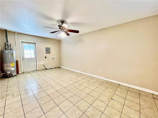 tiled spare room featuring water heater, electric panel, and ceiling fan