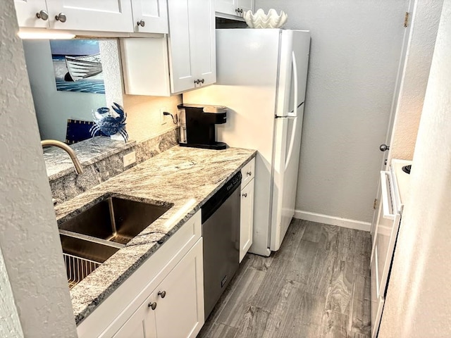 kitchen featuring white cabinetry, dishwasher, sink, light stone counters, and light hardwood / wood-style floors