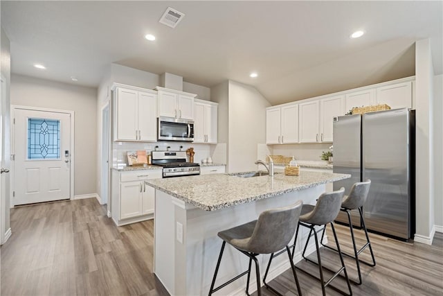 1142 Breebry Dr, Corpus Christi, TX 78415 - kitchen with appliances with stainless steel finishes, light wood-type flooring, white cabinetry, and recessed lighting
