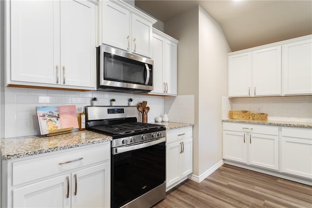 1142 Breebry Dr, Corpus Christi, TX 78415 - kitchen with stainless steel appliances, decorative backsplash, white cabinets, and vaulted ceiling