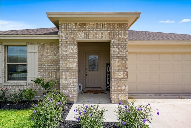 1142 Breebry Dr, Corpus Christi, TX 78415 - property entrance with a shingled roof, brick siding, driveway, and a garage