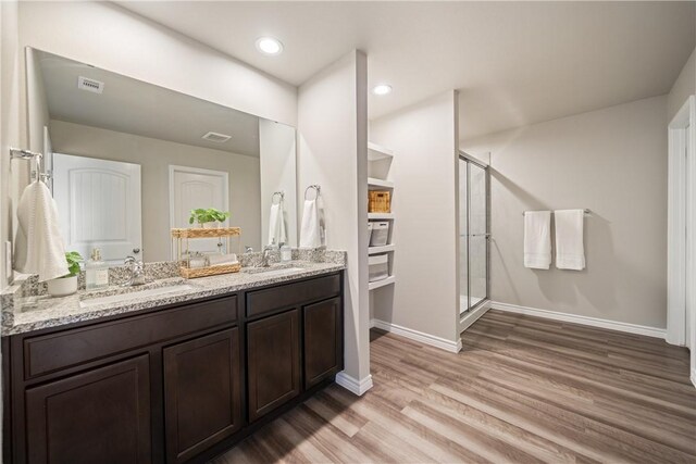 1142 Breebry Dr, Corpus Christi, TX 78415 - full bath featuring wood finished floors, double vanity, a shower stall, and recessed lighting