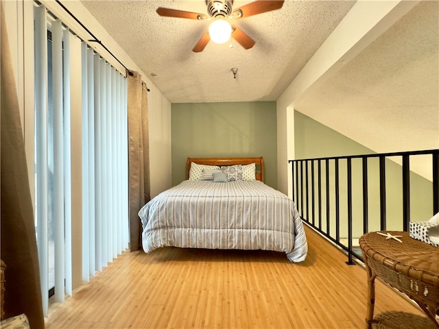 bedroom featuring ceiling fan, wood-type flooring, and a textured ceiling