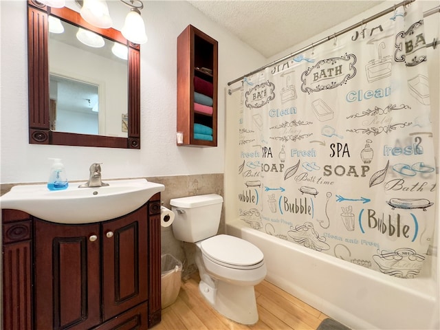 full bathroom featuring shower / bath combo, wood-type flooring, a textured ceiling, toilet, and vanity