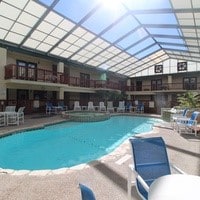 view of swimming pool featuring glass enclosure and a patio area