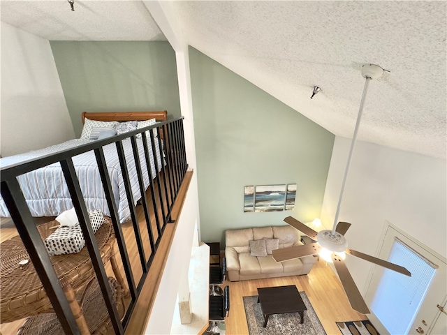 stairway with hardwood / wood-style floors, lofted ceiling, and a textured ceiling